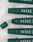 Green Mint Pasko lip balm tubes on a marble surface