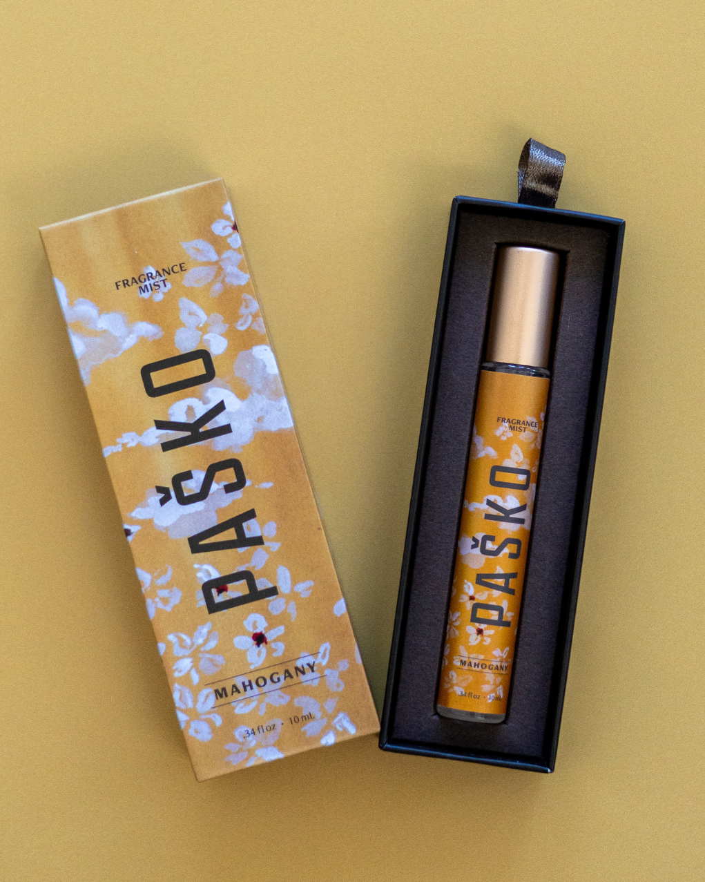 Pasko Mahogany perfume bottle and packaging on a yellow background