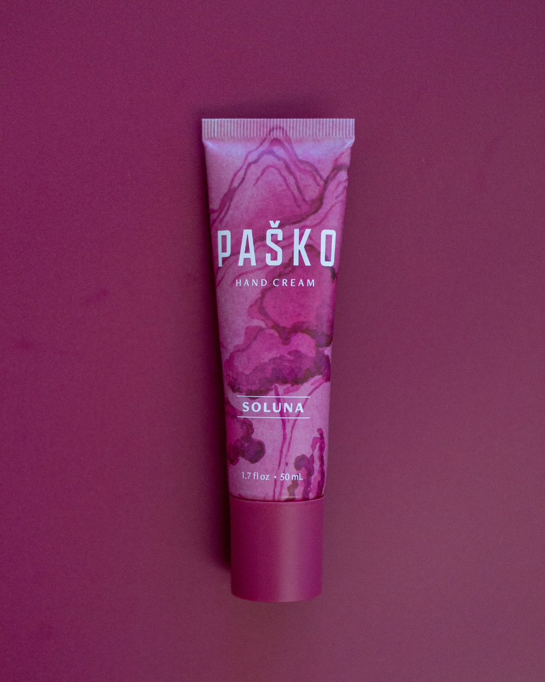 Pasko hand cream tube on a purple background
