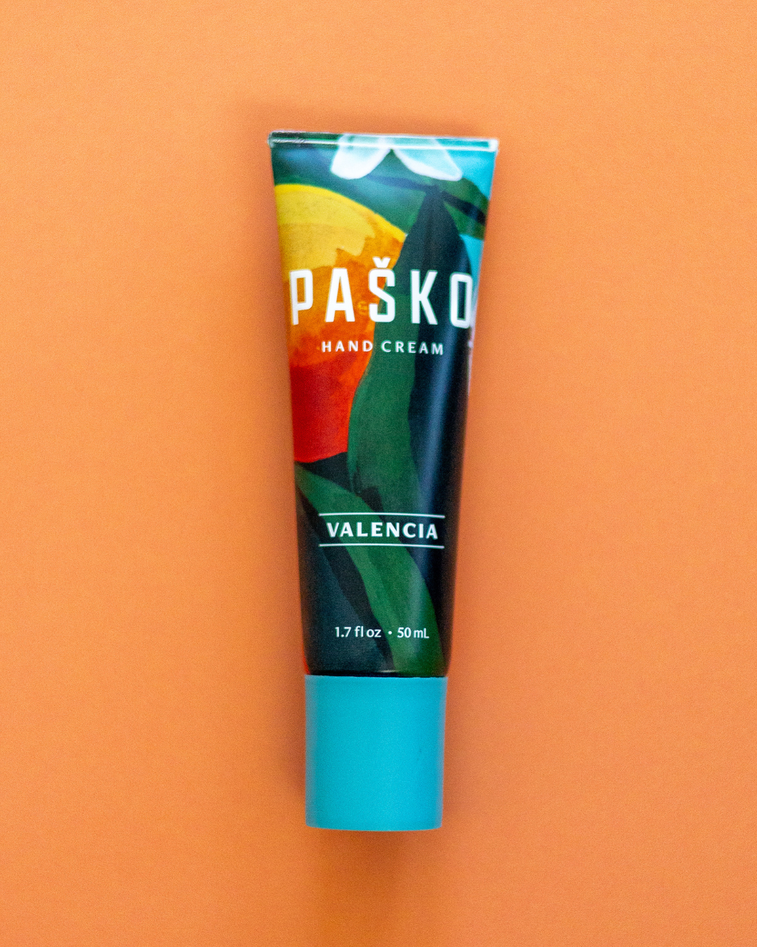 Pasko Valencia hand cream tube on an orange background